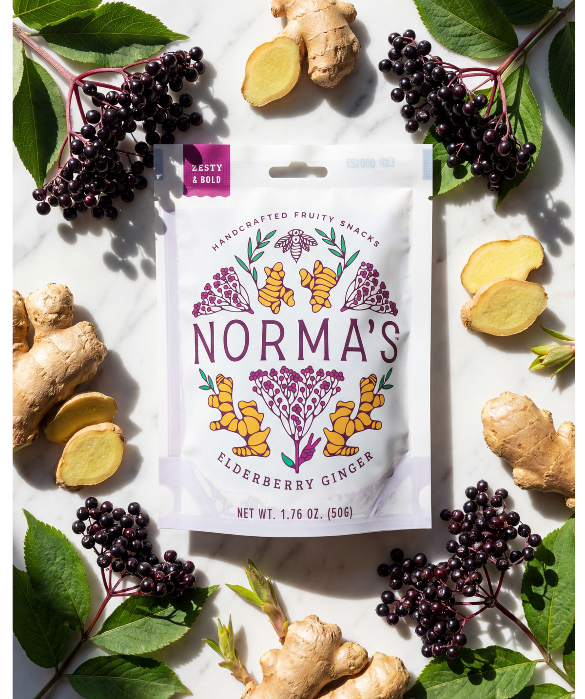 Norma's Elderberry Ginger fruit snacks package surrounded by fresh ingredients on a white background